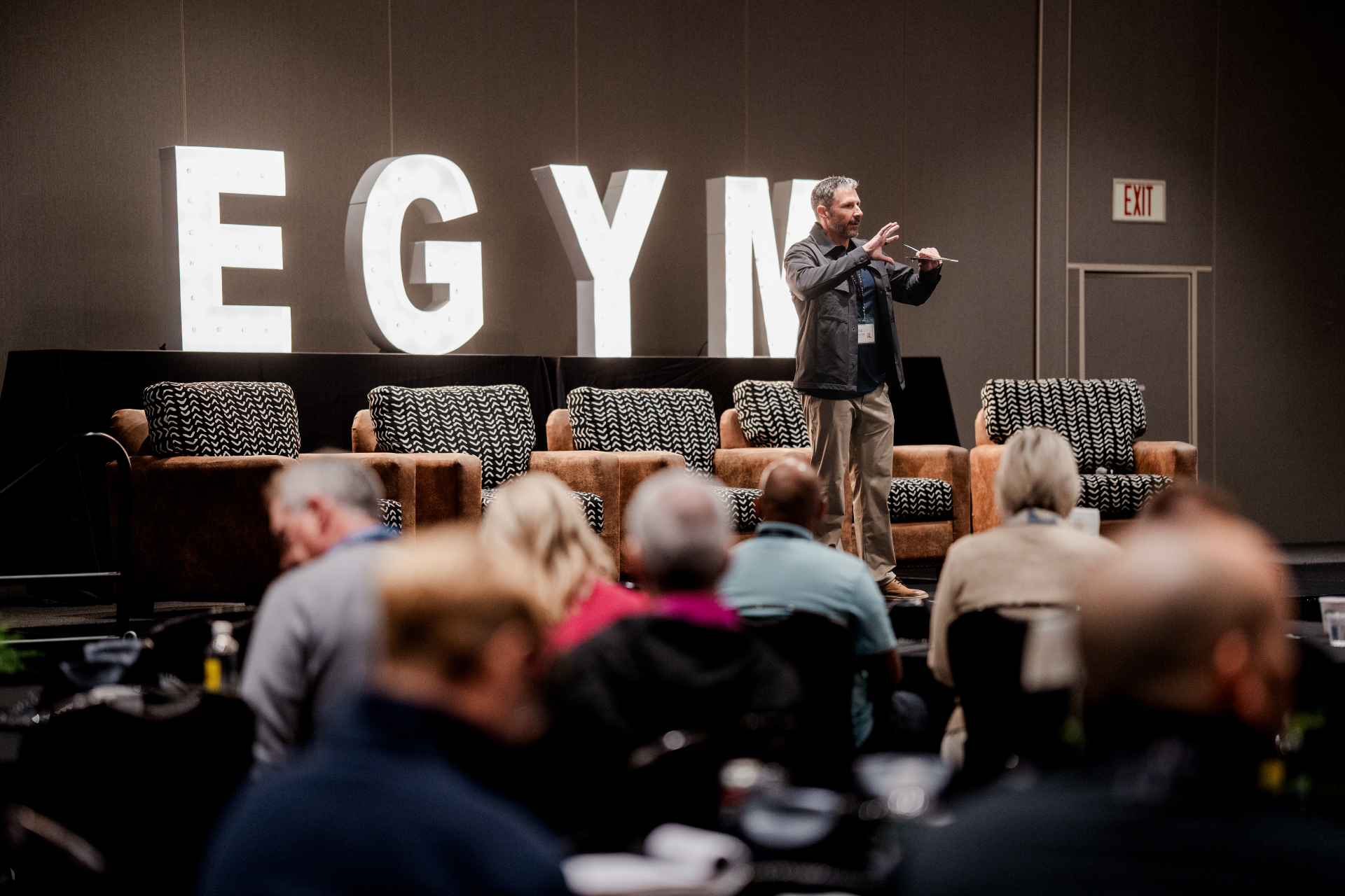 Eric Malzone on stage at an EGYM industry event, mid-conversation with the audience